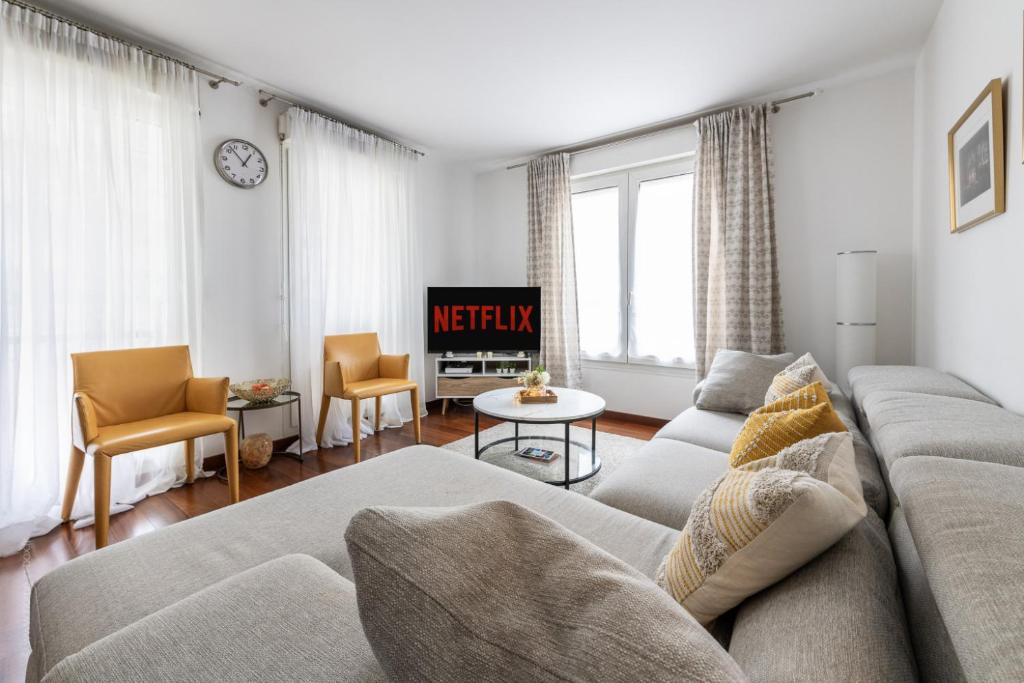 un salon avec un canapé et une télévision dans l'établissement Confort à Disneyland, Village nature*Netflix*Wi-Fi, à Bussy-Saint-Georges