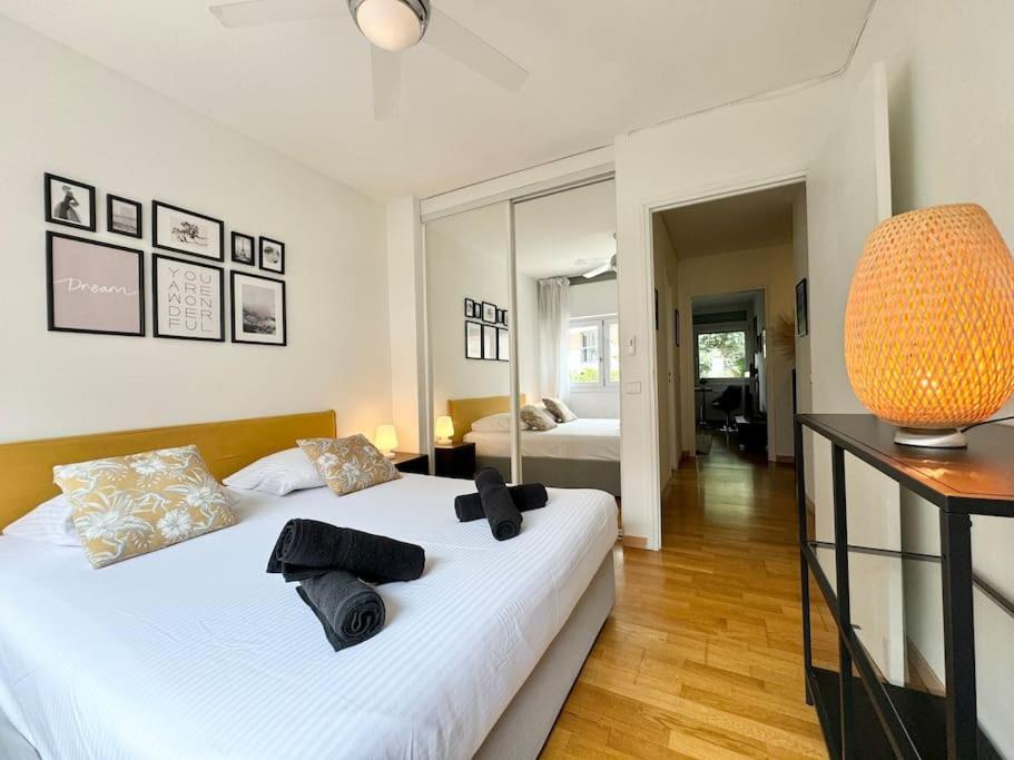 - une chambre avec un grand lit blanc et un grand miroir dans l'établissement Cosy 2 pièces élégant proche gare et port Vauban, à Antibes