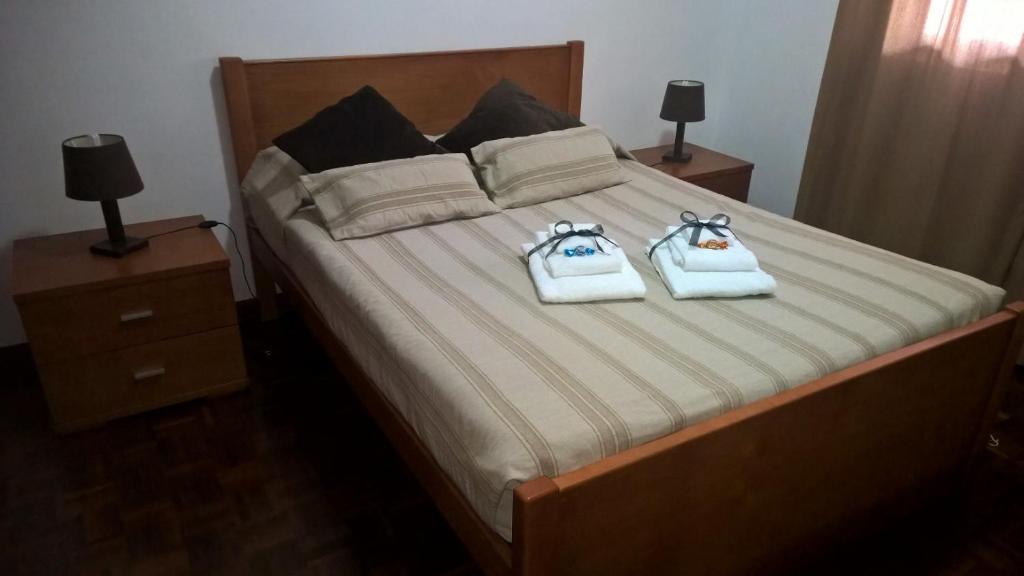 ein Schlafzimmer mit einem Bett mit zwei Handtüchern darauf in der Unterkunft Casa do Basalto in Ponta Delgada