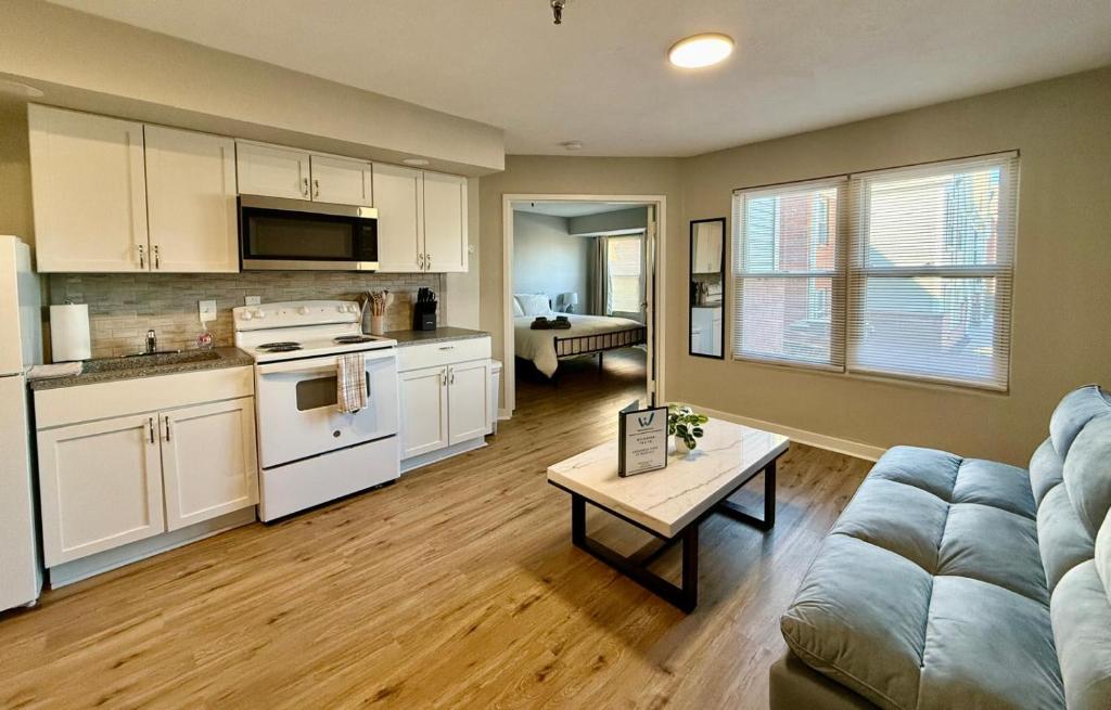 a kitchen and living room with a couch and a table at Aksarben View One Bedroom in Omaha