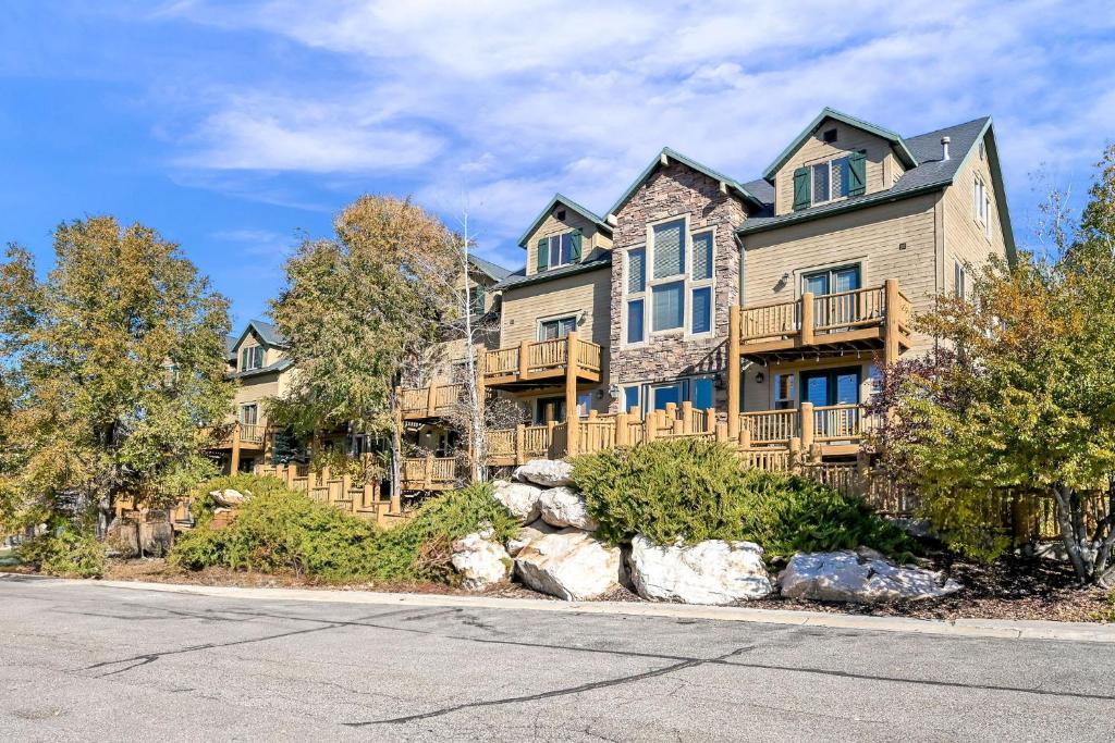 a large house on a street with trees at Eden Escape most desirable floor plans in all of Moose Hollow Luxury Condos in Eden