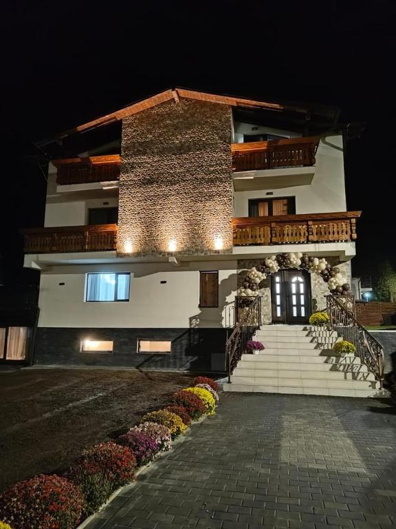 a building with stairs and flowers in front of it at La Ancuța-n Bucovina in Gura Humorului
