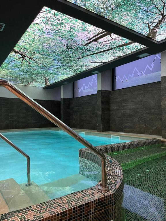 a swimming pool in a building with a large window at Forest Zlatni Bor in Zlatibor