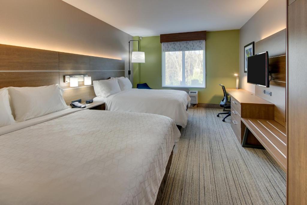 a hotel room with two beds and a flat screen tv at Holiday Inn Express & Suites Columbus - Ft Benning Maingate by IHG in Columbus