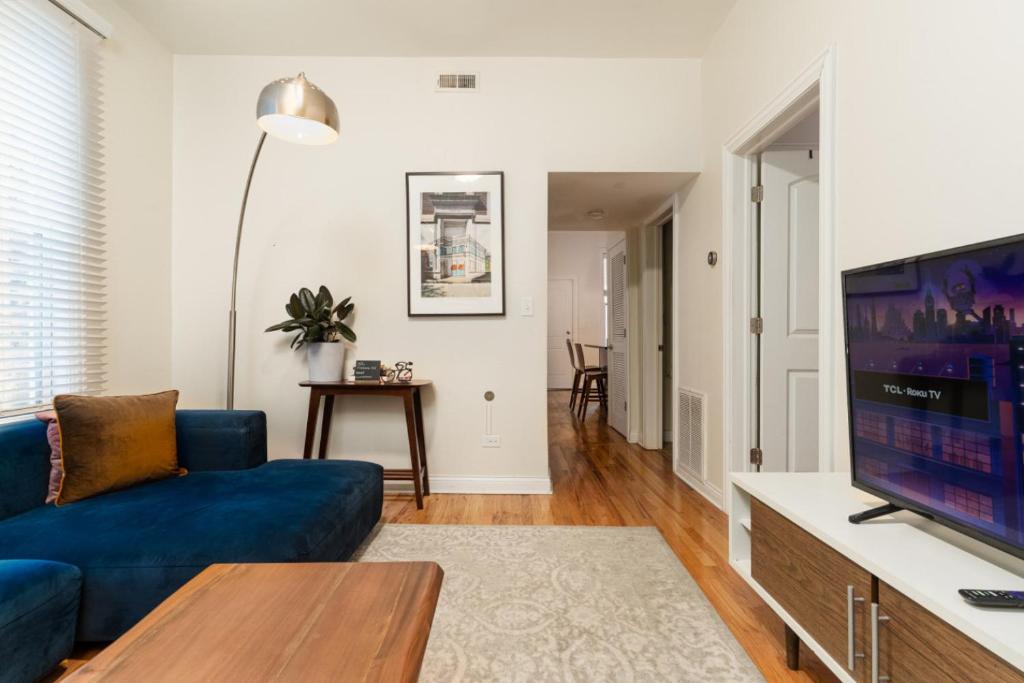 a living room with a blue couch and a tv at Wicker Park 2BR Modern Apartment DV3 in Chicago