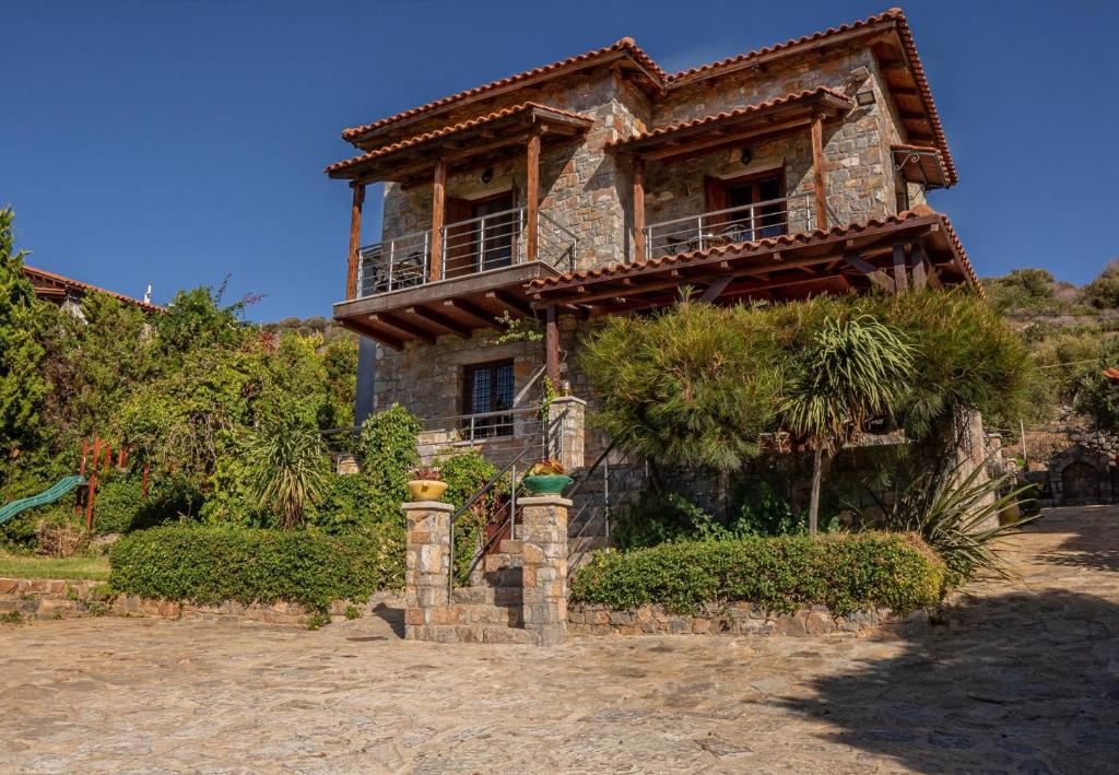a stone house with a balcony on top of it at Iris Stone Built Villa in Milatos