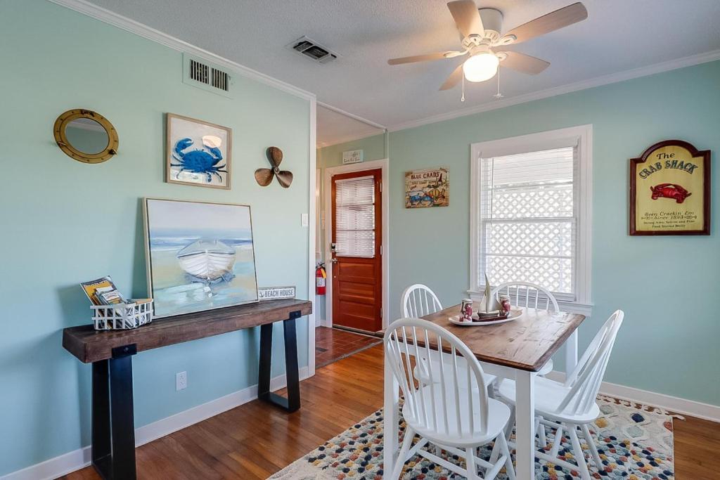 a dining room with a table and chairs and a ceiling fan at The Cozy Blue Cottage in Long Beach