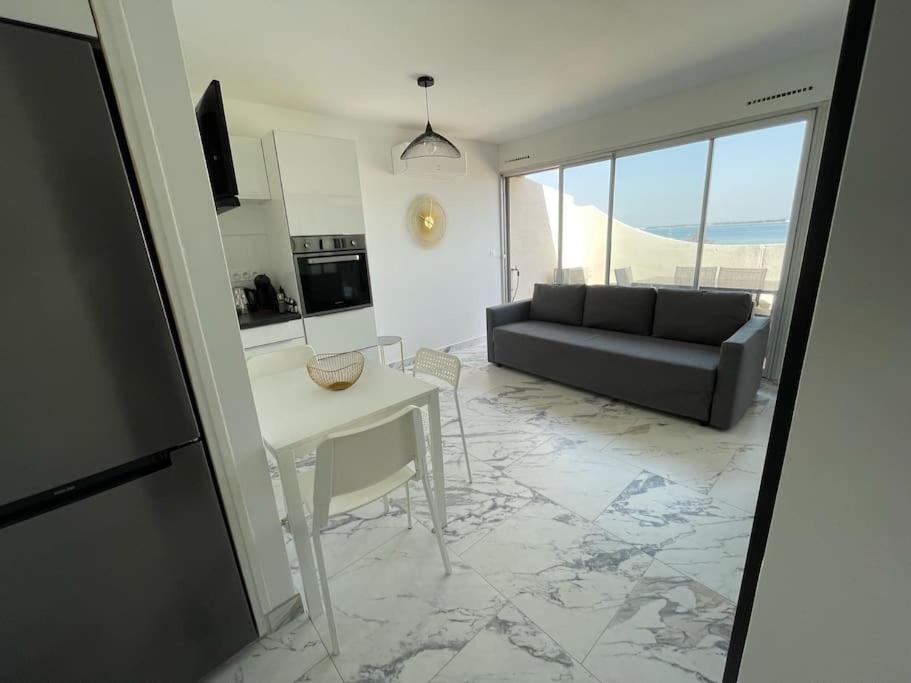 un salon avec un canapé et une table dans l'établissement Appartement T2 front de mer, vue panoramique, au Grau-du-Roi