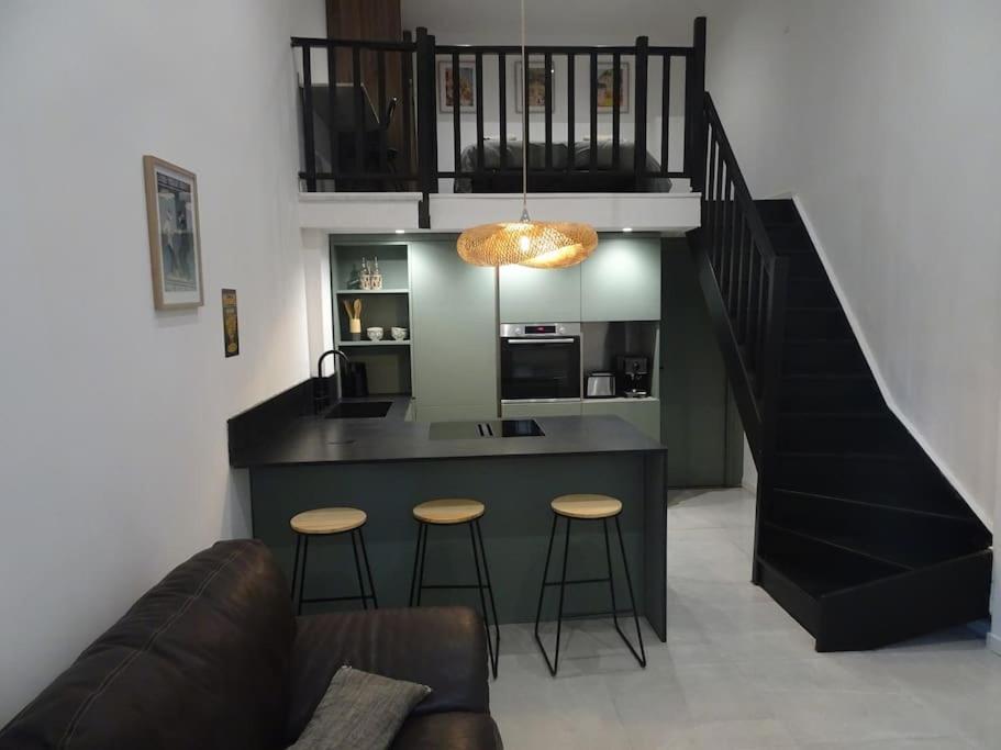 une cuisine avec un bar avec des tabourets et un escalier dans l'établissement Loft Cosy Marseille, à Marseille