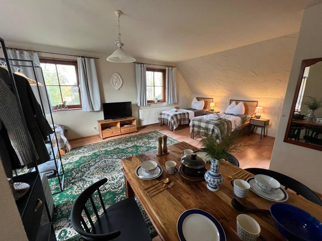a living room with a bed and a table at Ferienhaus Feldblick mit Kamin für 15 Personen in Rüdersdorf