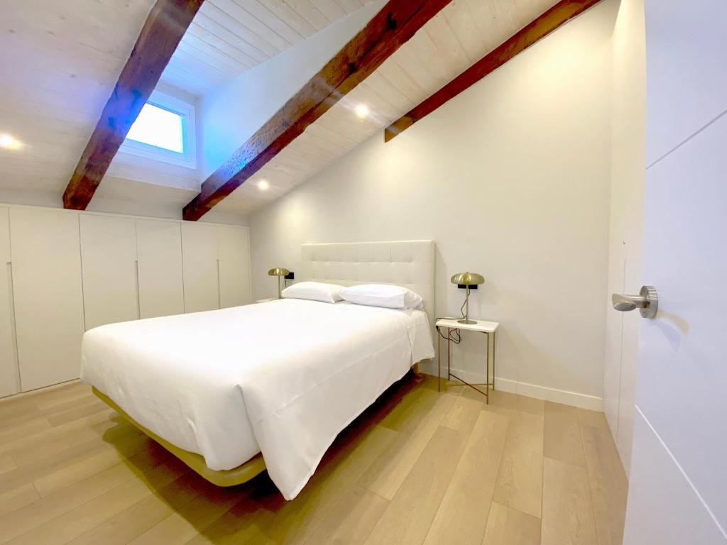 a bedroom with a large white bed and a window at San Juan Centro Histórico in Burgos