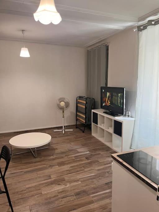 un salon avec une table et une télévision dans l'établissement Studio 30m2 à deux pas du centre-ville de Mulhouse, à Mulhouse