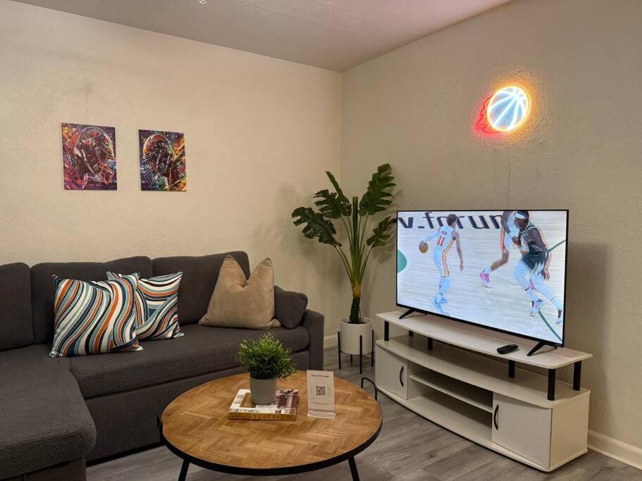 a living room with a couch and a flat screen tv at New comfortable and youthful sport in Fort Lauderdale