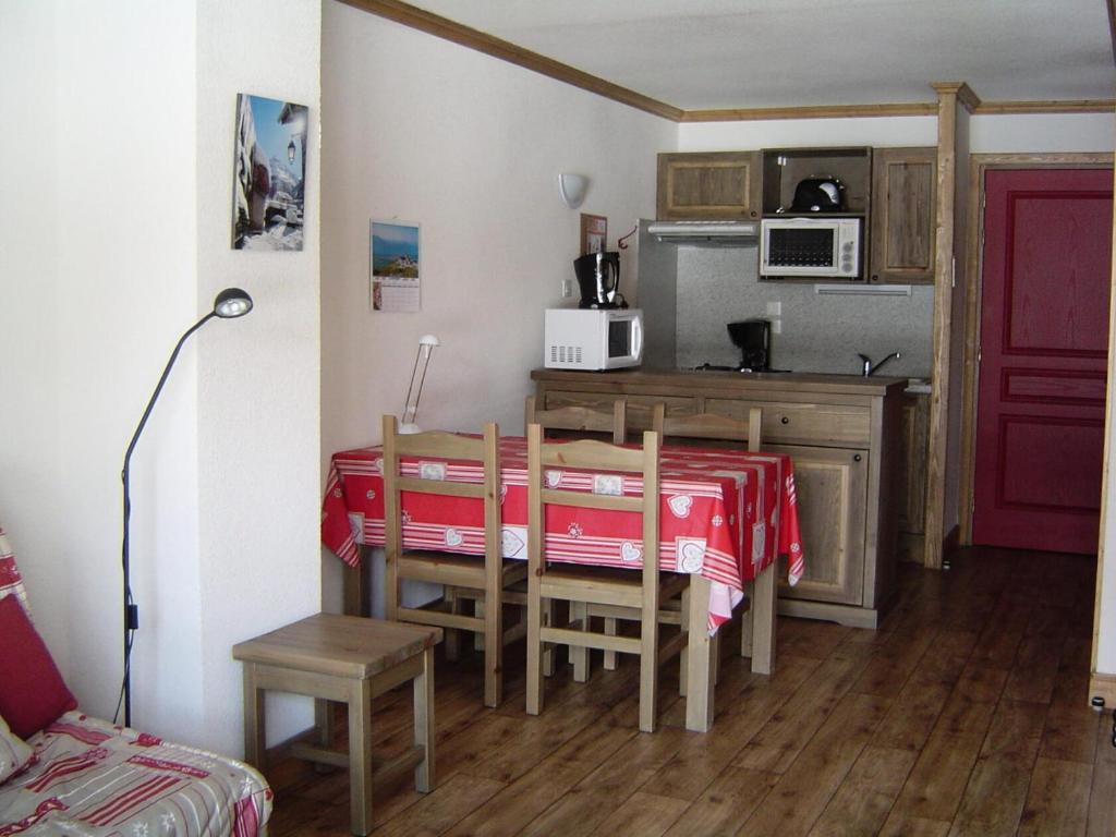 d'une cuisine avec une table et un chiffon rouge. dans l'établissement Résidence Le Clos Vanoise - 2 Pièces pour 6 Personnes MAE-4371, à Bessans
