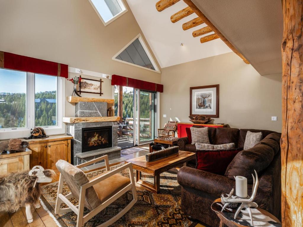 a living room with a couch and a fireplace at Saddle Ridge F5 home in Big Sky