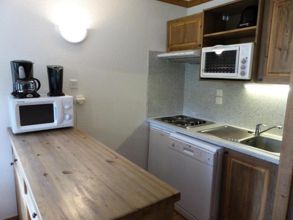 une petite cuisine avec un évier et un micro-ondes dans l'établissement Résidence Le Clos Vanoise - 3 Pièces pour 8 Personnes MAE-4331, à Bessans