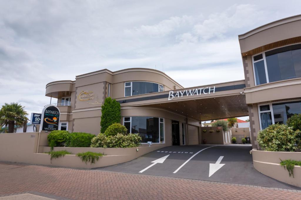 a building with a parking lot in front of it at Baywatch Motor Inn in Mount Maunganui