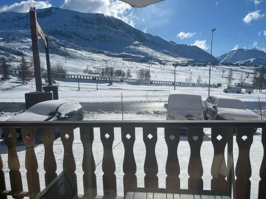 une cour enneigée avec des voitures garées dans la neige dans l'établissement Appart ski aux pieds Alpe d'Huez, à Huez