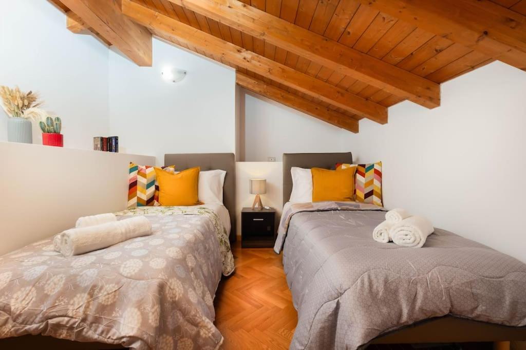 two beds sitting next to each other in a room at Borgo Palazzo - Vista Città Alta e Terrazza in Bergamo