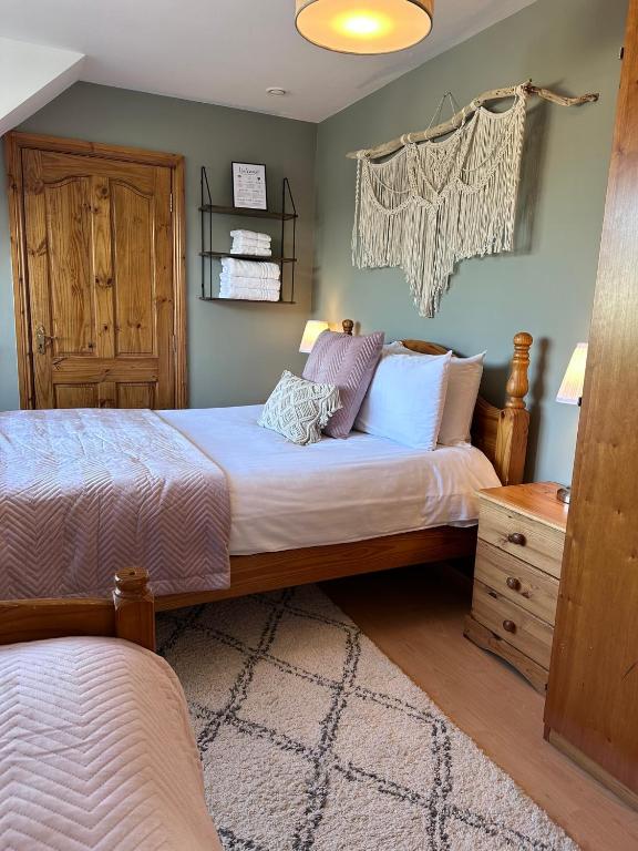 a bedroom with two beds and a dresser at Malahide Guest Rooms in Malahide