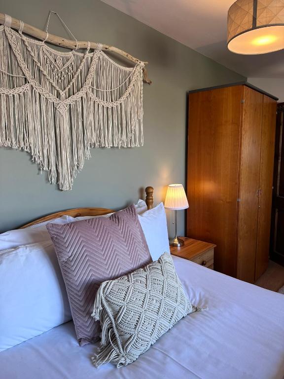 a bedroom with a bed with pillows and a curtain at Malahide Guest Rooms in Malahide