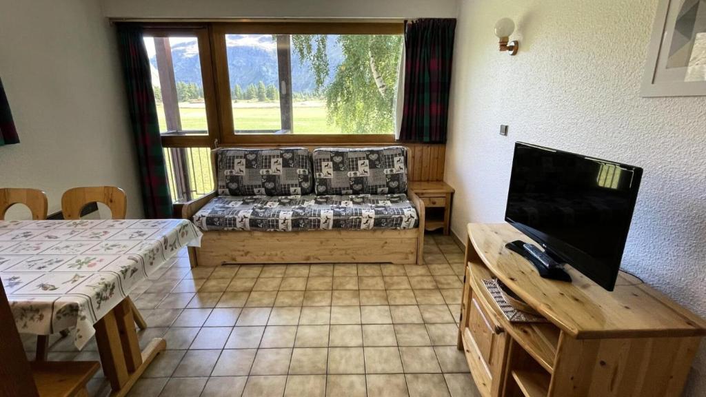 un salon avec un canapé et une télévision dans l'établissement Résidence Albaron - 3 Pièces pour 6 Personnes MAE-4701, à Bessans