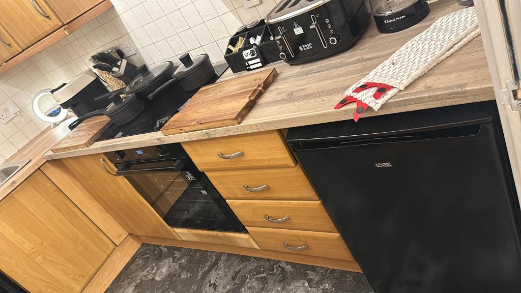 eine Küche mit einem schwarzen Geschirrspüler unter der Theke in der Unterkunft Cozy Apartment in Edinburgh