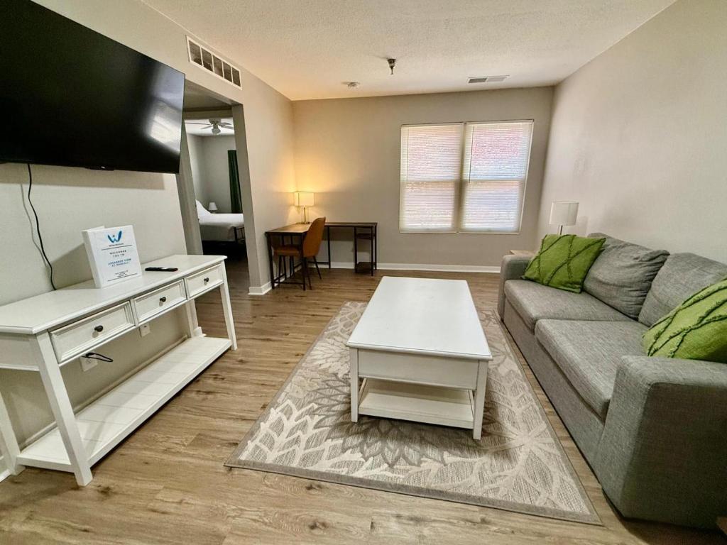 una sala de estar con un sofá y una mesa en Cozy Aksarben Living-close to I-80 & WFH desk, en Omaha
