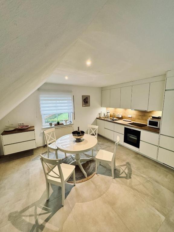 a kitchen with a table and chairs in a room at Ferienwohnung Amselweg Haiger in Haiger