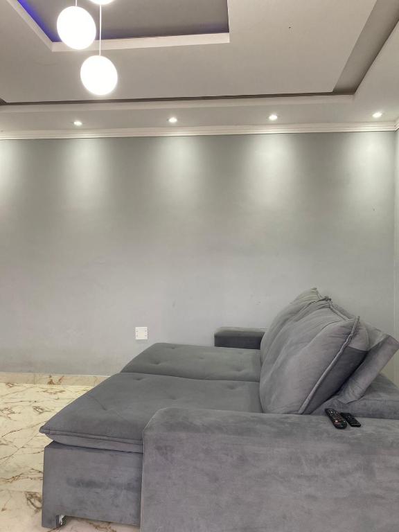 Ce lit se trouve dans un dortoir doté d'un mur blanc. dans l'établissement Casa na praia no Guarujá, à Guarujá