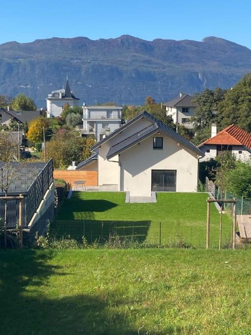 une maison blanche au-dessus d'un champ verdoyant et luxuriant dans l'établissement VILLA VUE LAC -3 chambres jardin-proche du lac et du Centre-ville , 2 places parking, à Mouxy