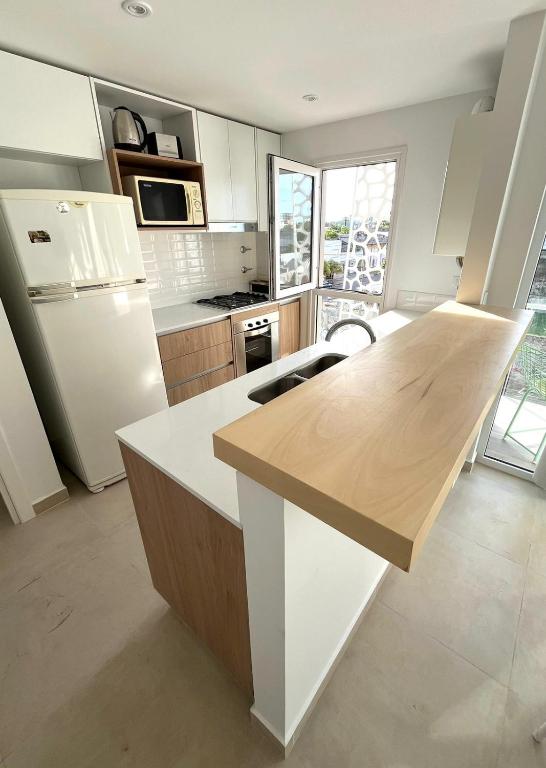 a kitchen with a white refrigerator and a counter top at Alquiler depto olavarria in Olavarría