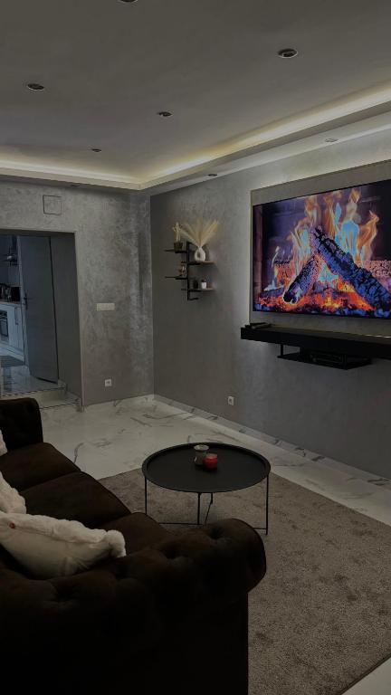 un salon avec un canapé et une télévision à écran plat dans l'établissement Lescapade, à Luxeuil-les-Bains