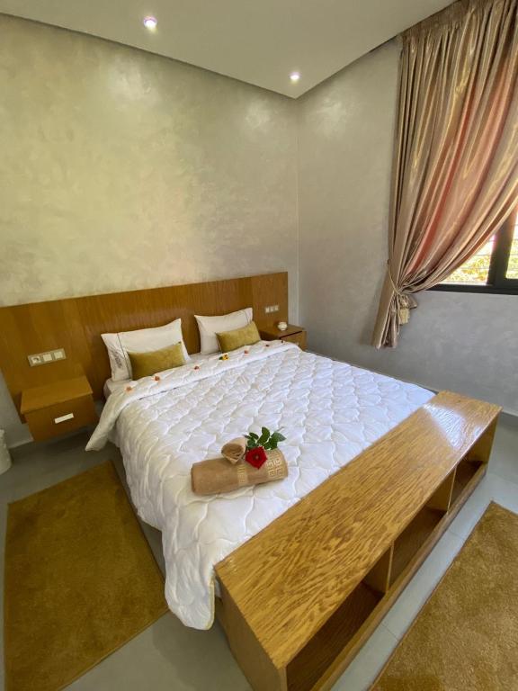 a bedroom with a large bed with a wooden table at charmante villa de luxe à Marrakech in Marrakesh