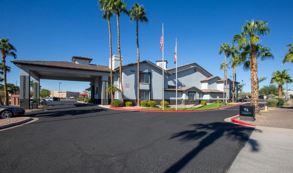 a street in front of a house with palm trees at The Hotel Serene Glendale Peoria, Surestay Collection by Best Western in Glendale