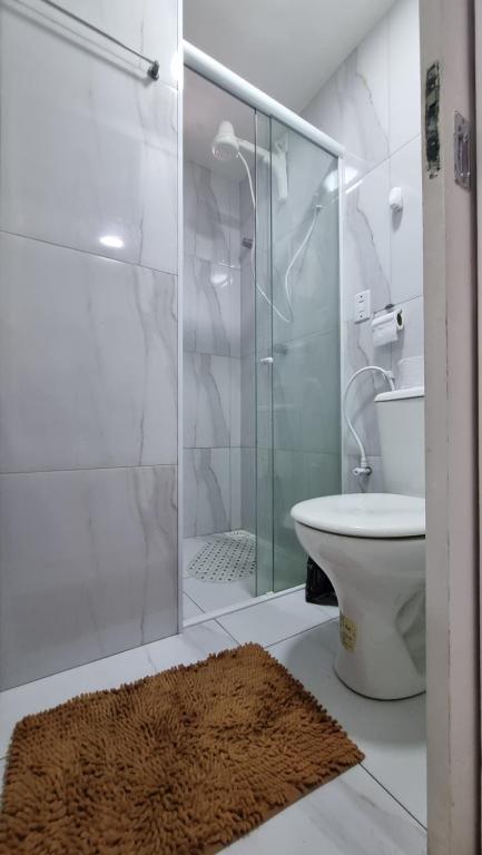 a bathroom with a toilet and a glass shower at Apartamento Dei Fiori in Guaramiranga