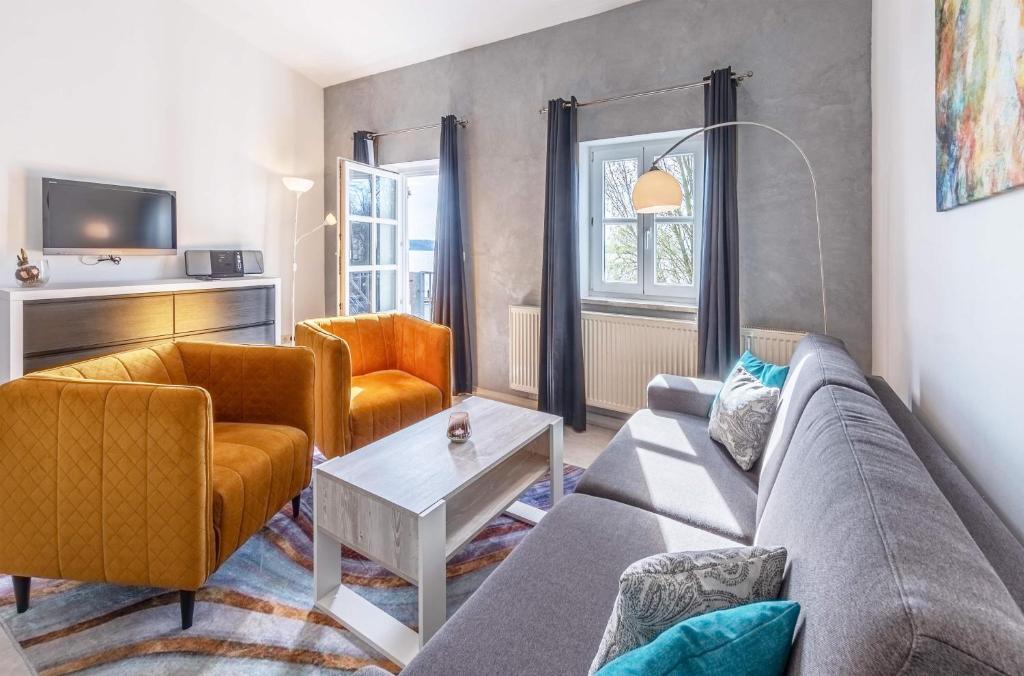 un soggiorno con un divano e due poltrone di Kietz-Idylle - Gemütliche Ferienwohnung mit Balkon und Zugang zu Wellnessbereich a Waren