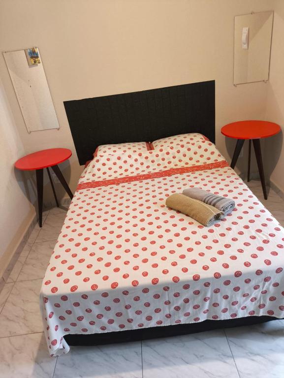 a bed with a polka dot sheets and two tables at Casa de Praia Família Próximo ao ExpoCentro BC in Balneário Camboriú