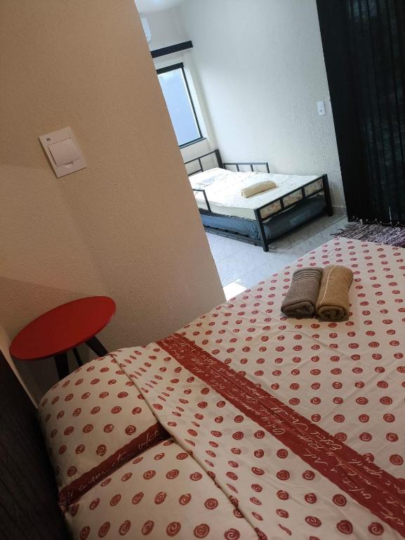 a bedroom with a bed with a red and white comforter at Casa de Praia Família Próximo ao ExpoCentro BC in Balneário Camboriú