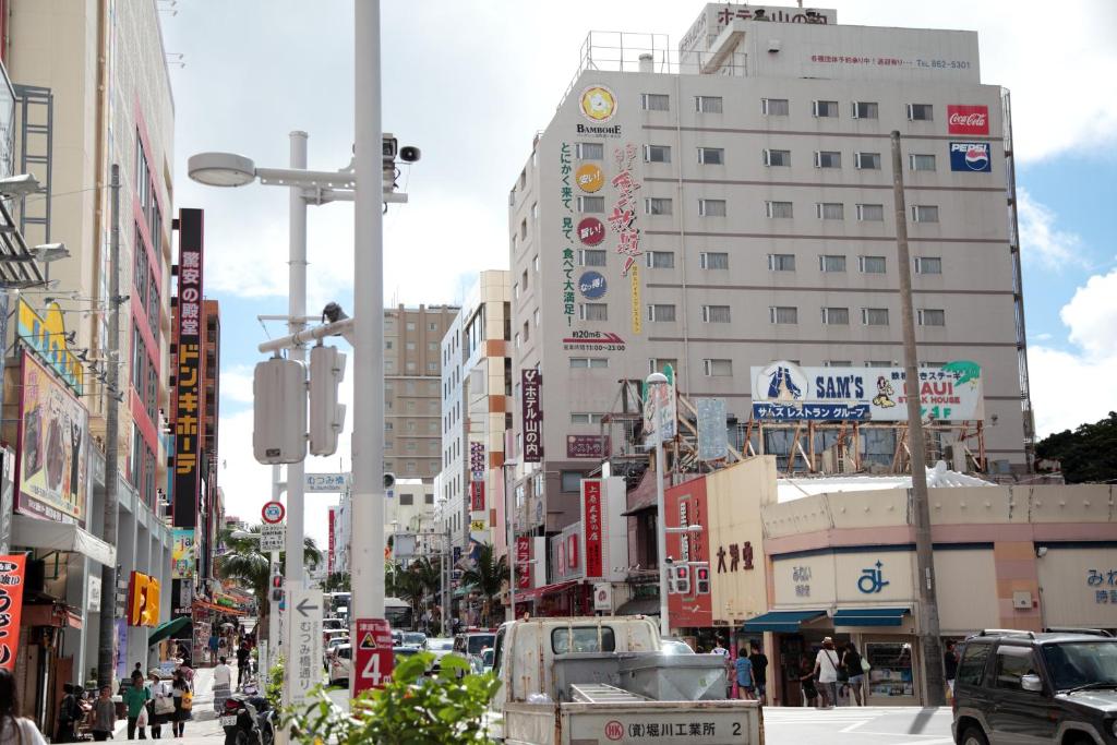 eine belebte Stadtstraße mit hohen Gebäuden und Autos in der Unterkunft Hotel Yamanouchi in Naha