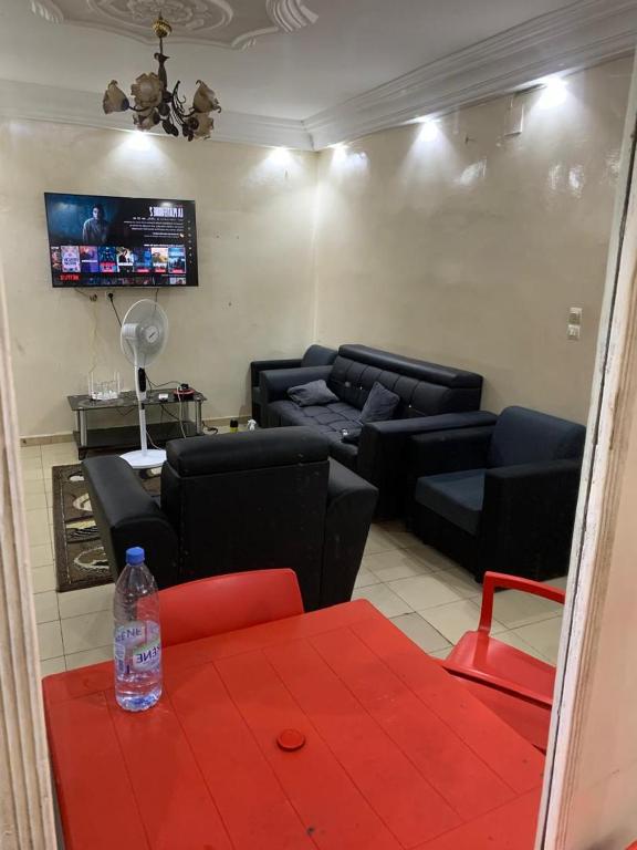 un soggiorno con mobili neri e un tavolo rosso di studio meublé a Dakar