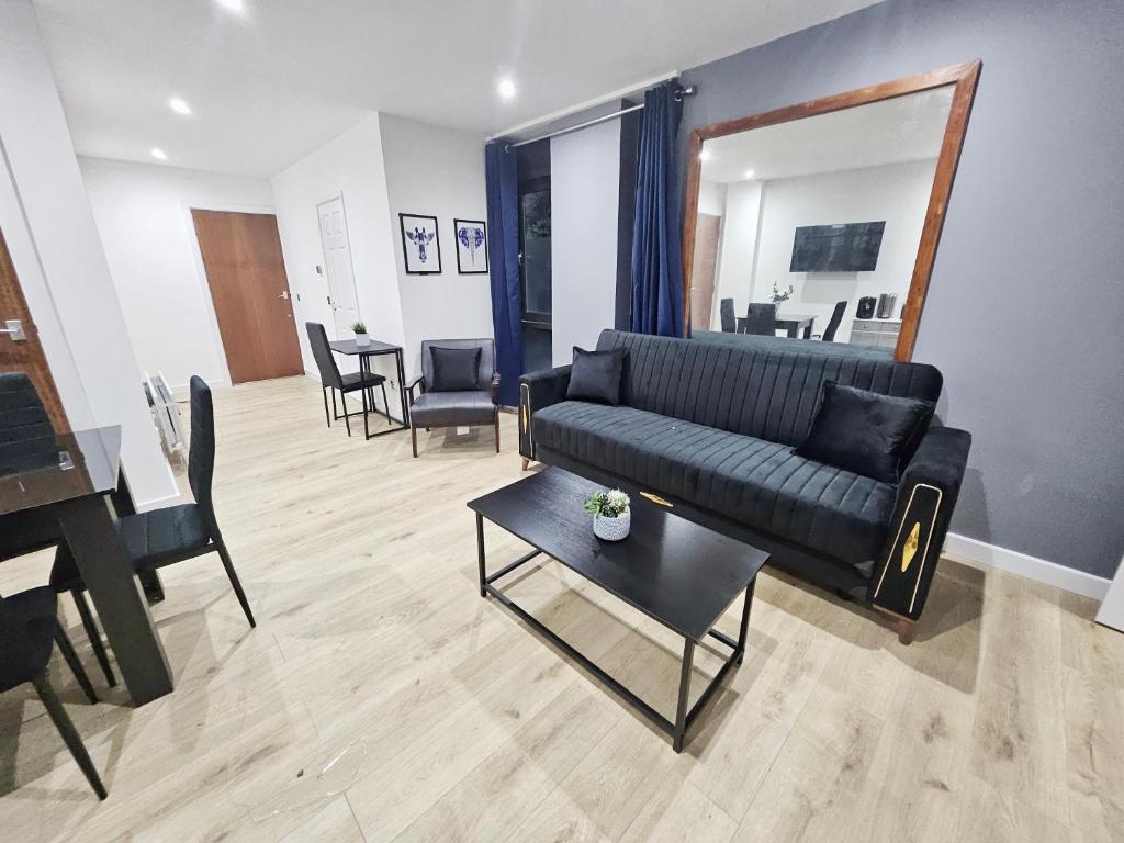 a living room with a black couch and a table at GDY1 - The Green Dragon Apartment in London