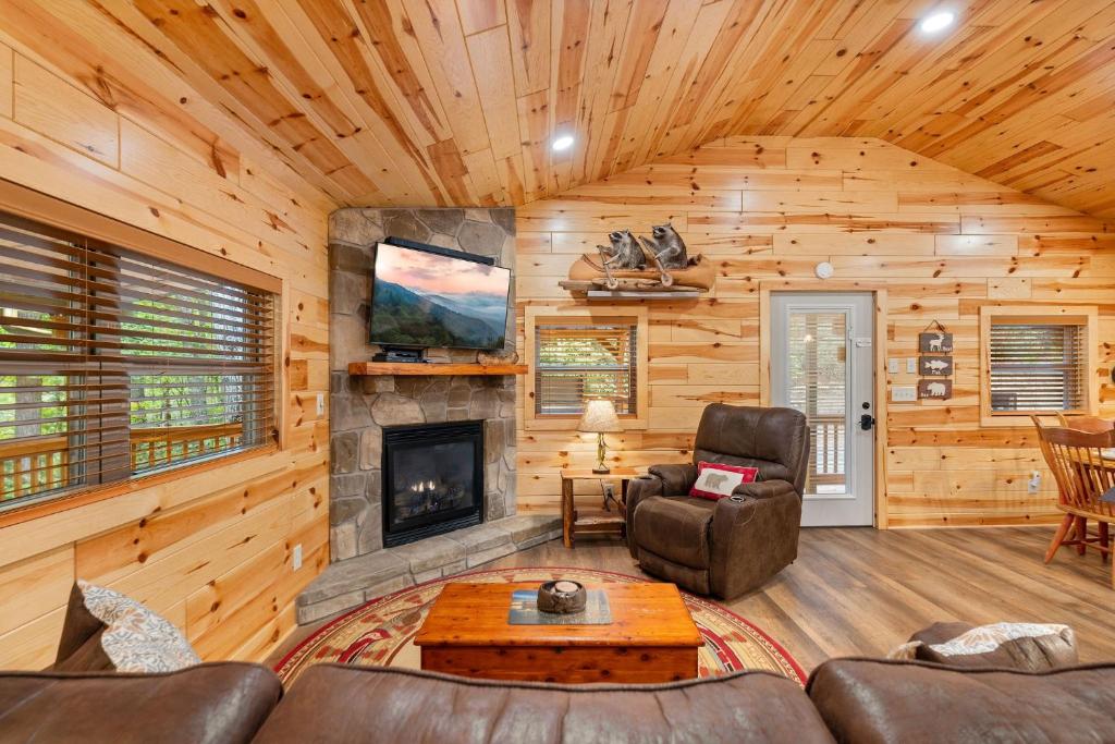 ein Wohnzimmer mit einem Kamin in einer Blockhütte in der Unterkunft Beside Still Water 2 - 2 Bedrooms, 2 Baths, Sleeps 6 home in Cosby