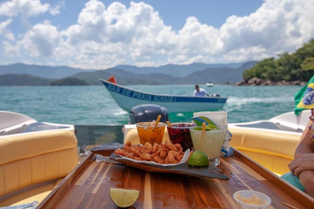 a tray of food on a table on a boat at JARDIM DAS PALMEIRAS II - HOME RESORT in Ubatuba