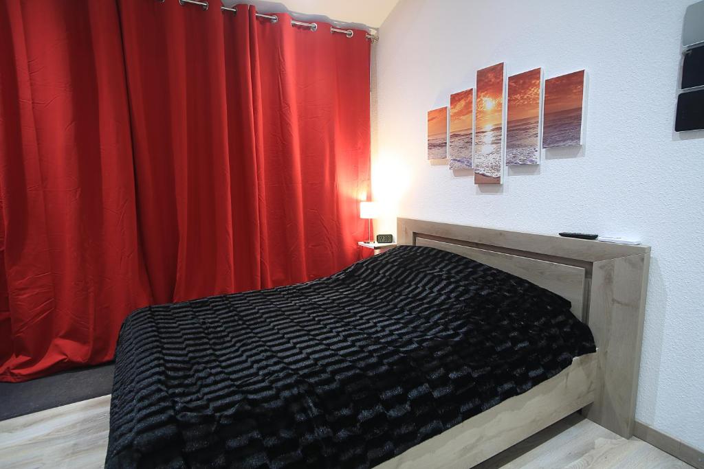 - une chambre avec un lit et un rideau rouge dans l'établissement FP La Cigale, à Camaret-sur-Aigues