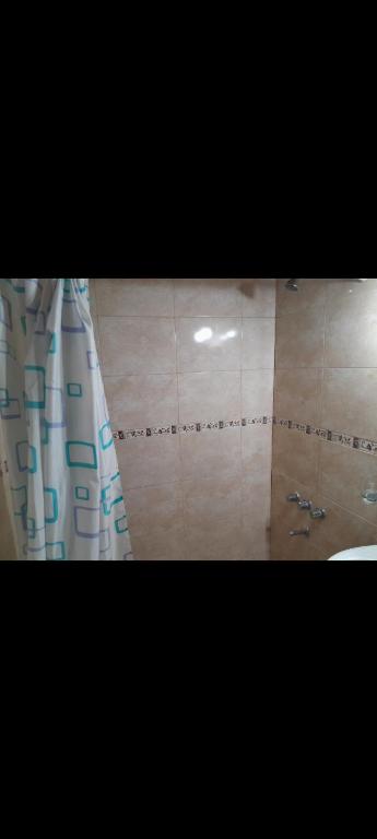 a bathroom with a shower curtain and a sink at El Arte-Sano in Tandil