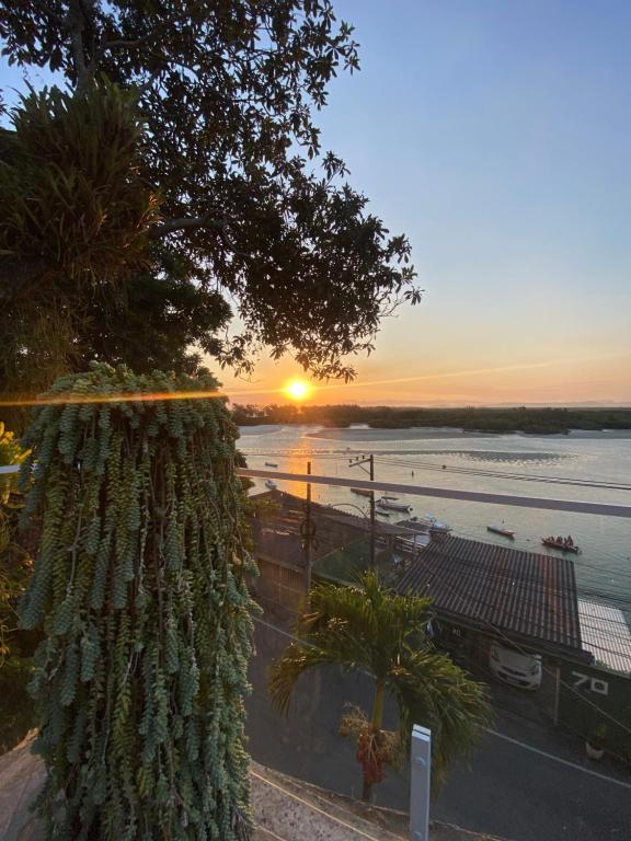 a tree with the sunset in the background at Casa da Vovó - Barra Guaratiba in Rio de Janeiro