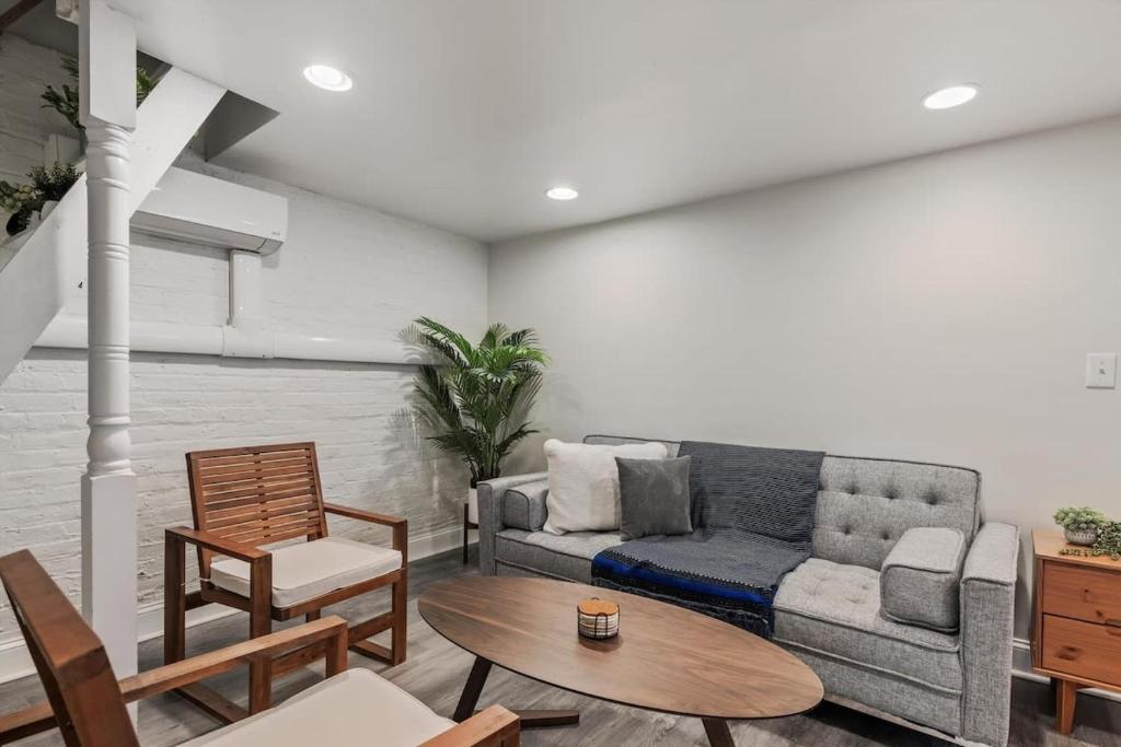 a living room with a couch and a table at Garden-Level 2-BR Apt in Historic Petworth Home in Washington, D.C.