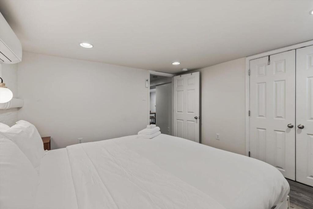 a white bedroom with a large bed and white cabinets at Garden-Level 2-BR Apt in Historic Petworth Home in Washington, D.C.