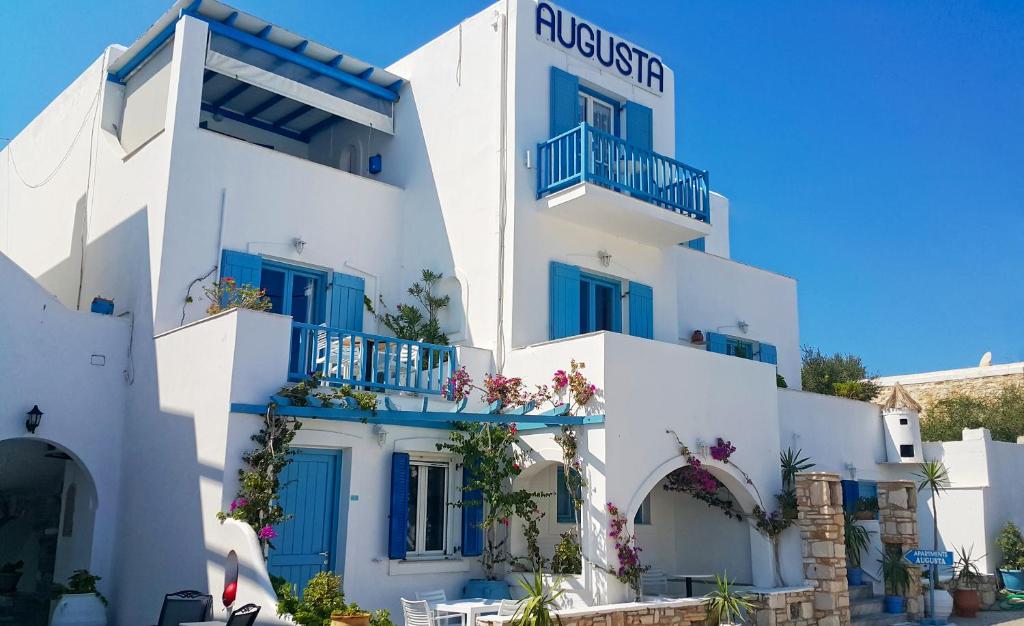a white building with blue doors and windows at Augusta Studios & Apartments in Naousa